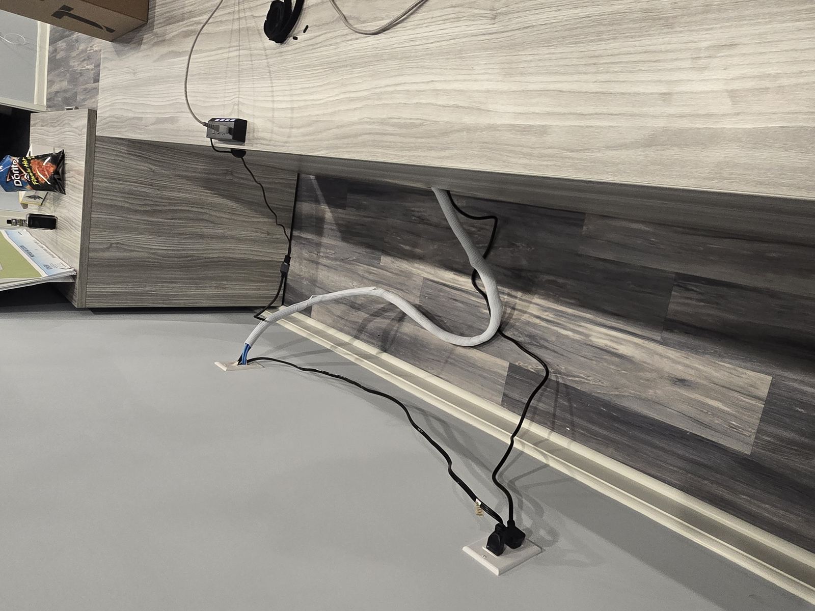 Cable routing along baseboard to wall outlet