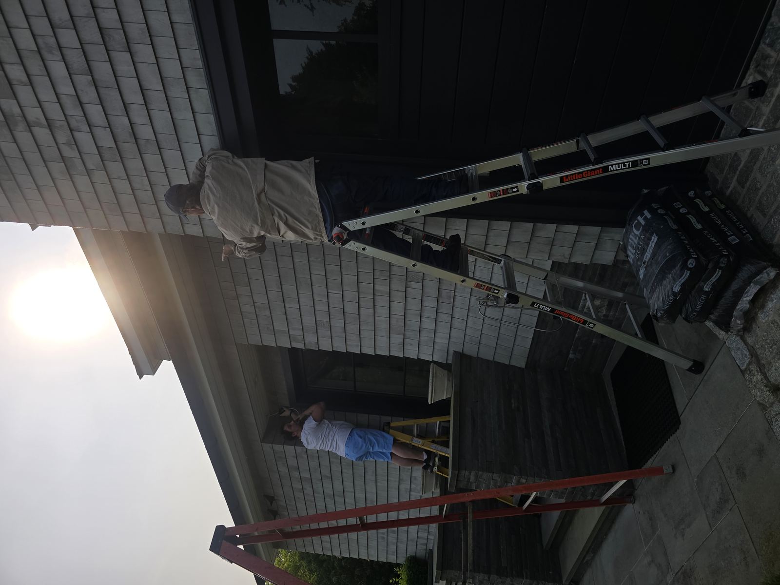 Technicians installing security camera on exterior wall