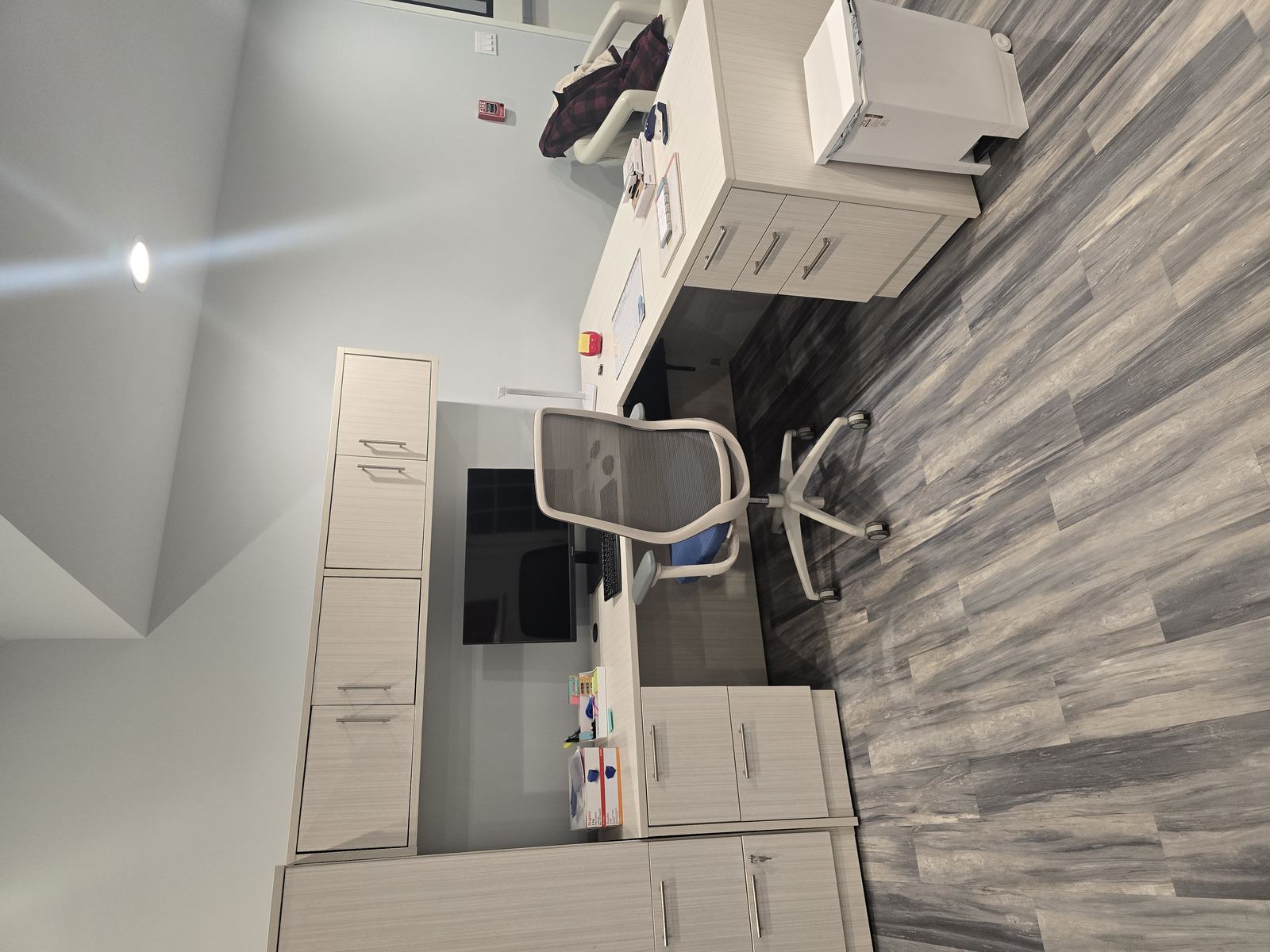 Finished office with L-shaped desk and storage cabinets